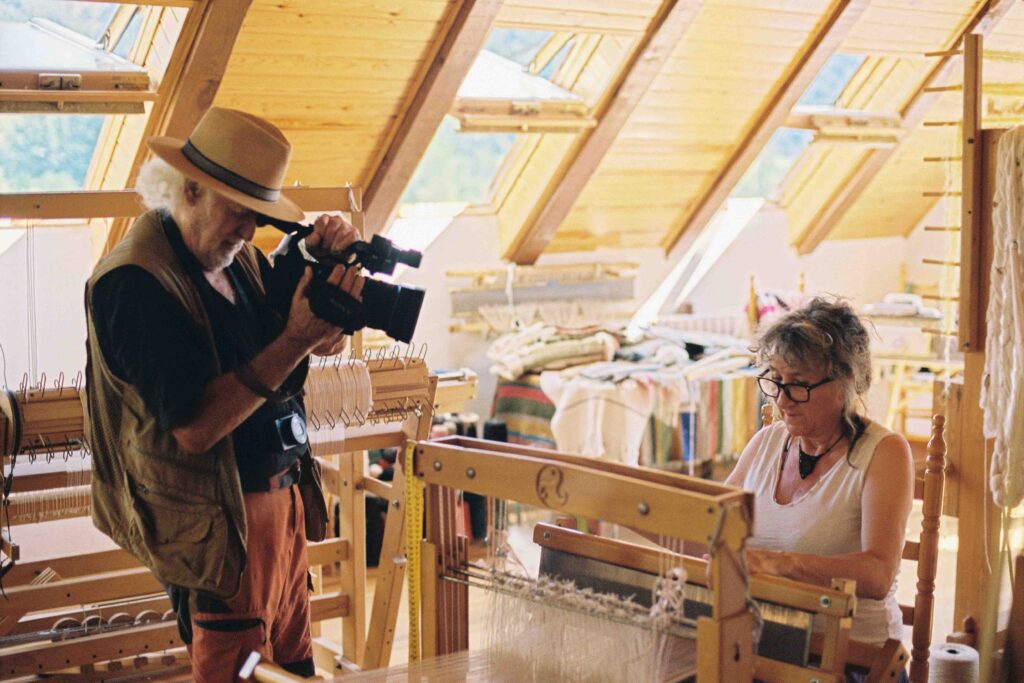 Eugenio Monesma filma l'Elena Requejo al teler del Museo-Taller de las Artes Textiles de San Juan de Plan